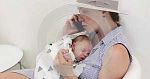 Young mother with her baby talking on cellphone