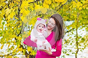 Young mother and her baby walking in atumn park photo