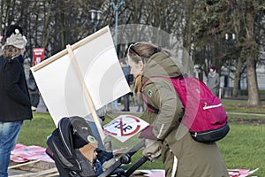 Young mother with her child in baby buggy and NO FUR sign placard at the march for Animal Advocacy in Riga, Latvia, Europe