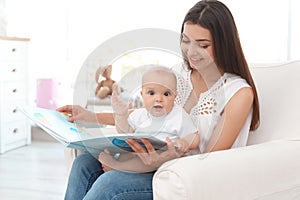 Young mother with her cute baby girl reading book