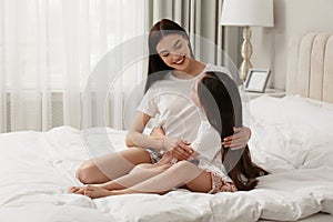 Young mother and her daughter on bed