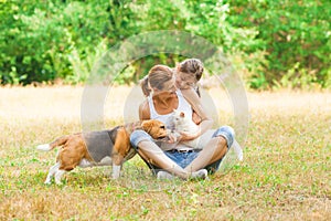 Young mother and her daughter playing with their cat and dog