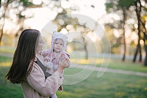Young mother and her little baby daughter having fun in a park