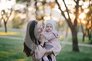 Young mother and her little baby daughter having fun in a park