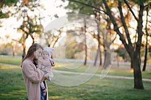Young mother and her little baby daughter having fun in a park