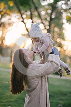 Young mother and her little baby daughter having fun in a park