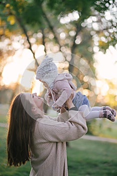 Young mother and her little baby daughter having fun in a park