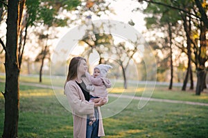 Young mother and her little baby daughter having fun in a park