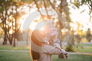 Young mother and her little baby daughter having fun in a park