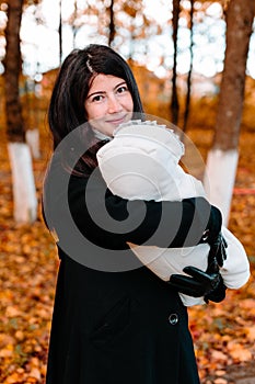 Young mother with her little baby on hand in autumn park