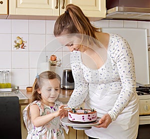 Young mother and her little daughter carry a decorated blueberry cheesecake.