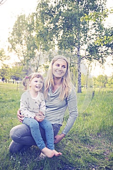 Young mother and her little daughter are enjoying life in park