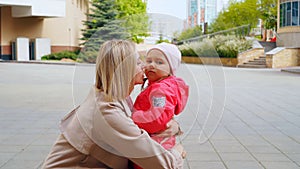 Young mother and her little daughter love each other, hugging and kissing.