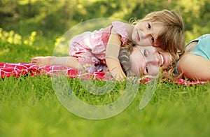 Young mother and her little daughter playing on grass