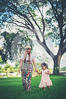 Young mother and her little daughter walking