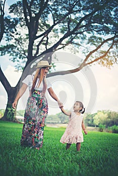 Young mother and her little daughter walking