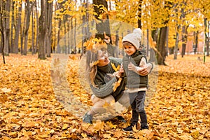 Young Mother with her little son in the autumn park have a fan. Yellow foliage, outdoor time with kids. Independent Happy Single