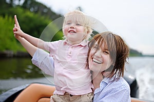 Young mother and her little son enjoy boating