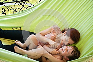 Young mother and her little son relaxing in a hammock