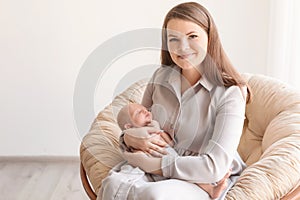 Young mother with her newborn baby in papasan chair