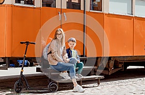 Young mother with her son near the orange tram. Scooter near the cafe in the old tram. Journey to Bydgoszcz.