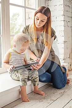 Young mother and her son toddler playing at home