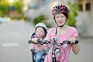 Young mother and her toddler girl riding a bicycle