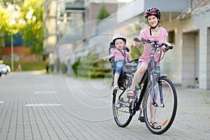 Young mother and her toddler girl riding a bicycle