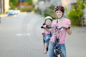 Young mother and her toddler girl riding a bicycle