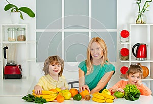 Young mother and her two children eating fruits and drinking smoothie, mothers day concept, Healthy food at home.