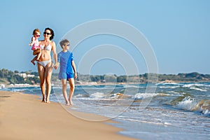 Young mother with her two kids on tropical beach vacation