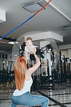 Young mother with her young son in the gym