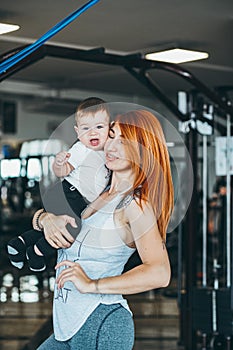 Young mother with her young son in the gym