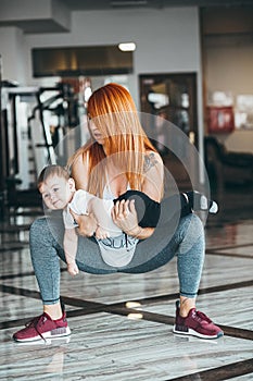 Young mother with her young son in the gym