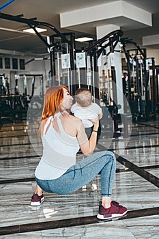 Young mother with her young son in the gym