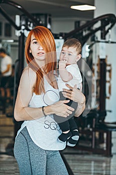 Young mother with her young son in the gym