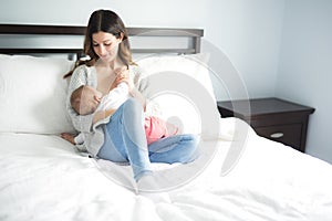 Young mother holding her baby child. Mom nursing baby.