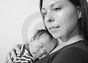 Young mother holding her newborn child. Mom nursing baby.