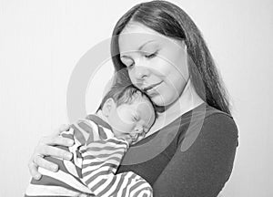 Young mother holding her newborn child. Mom nursing baby.