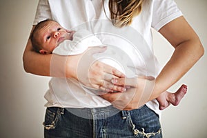 Young mother holding her newborn child. Mom nursing baby. Family