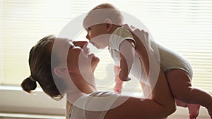 Young mother holding her newborn child. Mom nursing baby. Woman and new born boy relax in bedroom. Mother breast feeding