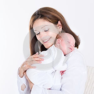 Young mother holding her newborn sleeping baby