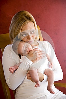 Young mother holding newborn baby boy in arms