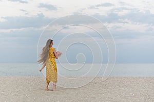 Young mother holds a child in her arms by the sea. Simple life with children