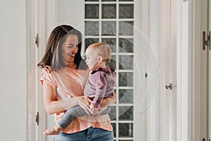 young mother at home playing with her adorable one year old baby girl. family time