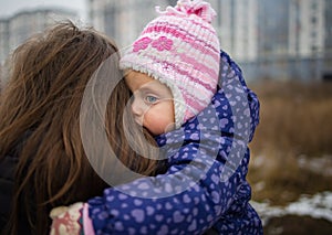 Young Mother Hugging And Caressing Her Little Child Outdoor In Winter