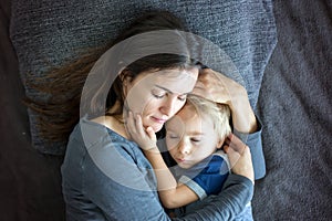Young mother, hugging her child in bed, positive emotion, love, happiness, peace