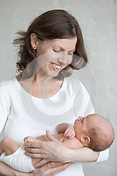 Young mother hugging her newborn child