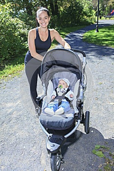 Young mother jogging with a baby buggy