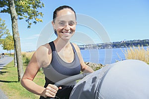 Young mother jogging with a baby buggy